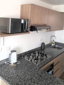a kitchen with a stove and a microwave at Cosy Mountain View 3BR Apartment, Prime Location! in Floridablanca +24 photos