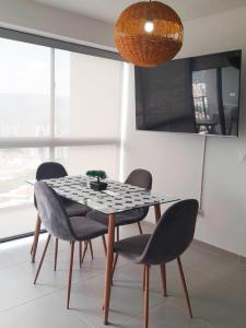 a dining room table with four chairs and a light fixture at Cosy Mountain View 3BR Apartment, Prime Location! in Floridablanca