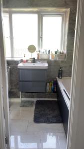 a bathroom with a sink and a tub and two windows at A house near Etihad and Manchester town centre in Manchester