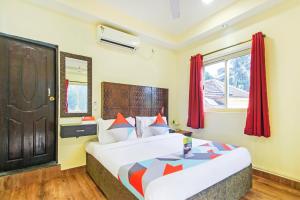 果阿旧城FabHotel Golden Nest Deluxe - Nr Calangute Beach的一间有床和窗户的酒店房间
