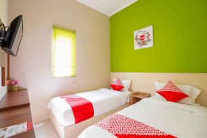 Postel nebo postele na pokoji v ubytování Hotel O Surabaya near Surabaya Town Square formerly Kupang Gunung Residence