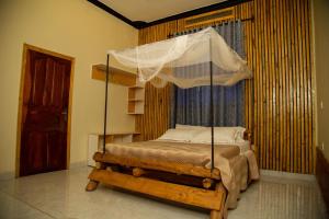 a bedroom with a canopy bed in a room at Henotes B&B in Kamuli