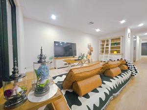 Una sala de estar con un sofá y un televisor. en Eden - Kaws 伊甸园 - 潮熊, en Ascot Park