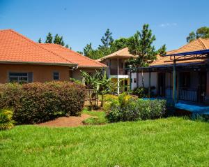 a house with an orange roof and a yard at Henotes B&B in Kamuli