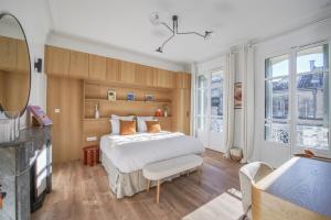 a bedroom with a large white bed and two windows at Villa Victor Hugo by Odomo in Avignon