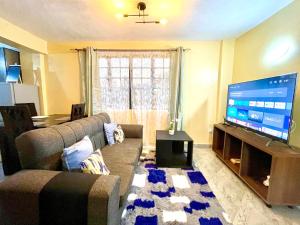 a living room with a couch and a flat screen tv at Countryside Apartment 1 in Kiambu