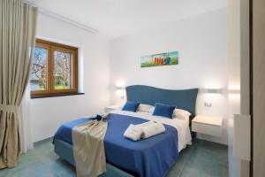 アジェーロラにあるLa Dimora Dei Nonni Apartmentsのベッドルーム(青と白のベッド1台、窓付)