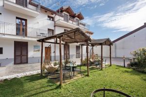 アジェーロラにあるLa Dimora Dei Nonni Apartmentsの建物の前にパティオ(テーブル、椅子付)