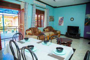 a living room with a table and chairs and a television at Henotes B&B in Kamuli