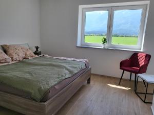 Sankt Michael ob BleiburgAppartements und Vinoteka DAVID的一间卧室配有一张床和一把椅子,还有两个窗户