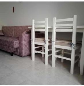 a living room with two white chairs and a couch at Everest in Golem