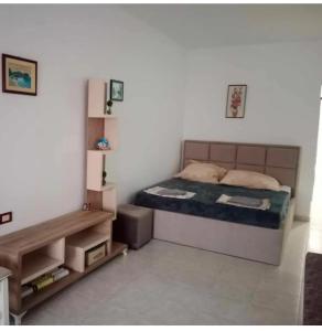 a small bedroom with a bed and a night stand at Everest in Golem