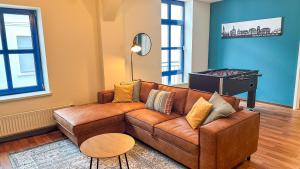 a living room with a brown couch and a table at MaBu Homes - Mitten in Nienburg in Nienburg