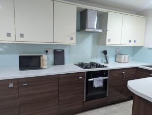 a kitchen with white cabinets and a stove top oven at South Shields Executive Apartment in South Shields +40 photos
