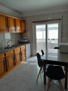 a kitchen with a table and chairs and a dining room at Ancora beira-mar in Vila Praia de Âncora +4 photos