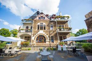 un gran edificio de piedra con mesas y sillas en Hotel Villa Vinum Cochem, en Cochem