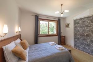 een slaapkamer met een bed en een raam bij Appartement spacieux avec vue in Saint-Gervais-les-Bains