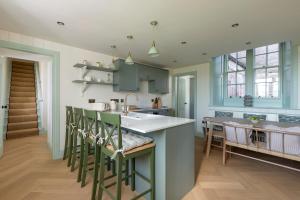 een keuken met een wastafel en een aanrecht met stoelen bij Montagu in Thornhill