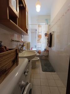un piccolo bagno con lavandino e WC di Loano Experience - 70m dal mare a Loano