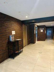 an empty hallway with a brick wall and a table at Leopard Shinsaibashi 心斎橋 505 in Osaka