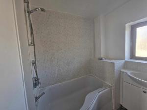 a bathroom with a bath tub and a sink at Spacious Large 4 Bed Contractor in Dallington