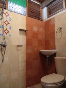 ein Badezimmer mit Toilette und Waschbecken in der Unterkunft Melati Double Studio with Shady Balcony Upstairs in Timuran