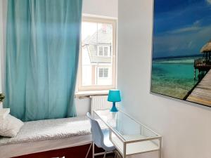 a bedroom with a window and a table with a lamp at Hostel 44 in Sopot