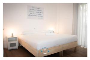a white bedroom with a large bed and a table at Ostia Holiday La Dolce Sosta Executive in Lido di Ostia