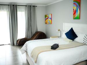 a bedroom with a large white bed with blue pillows at 5@Partridge Guesthouse in Newcastle