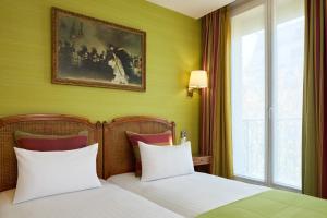 Postel nebo postele na pokoji v ubytování Timhotel Invalides Eiffel