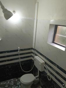 baño con aseo y una luz en la pared en Shiva Moon Guest House, en Gokarna