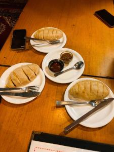 three plates of food on a wooden table at Perfect Home for Stay in Jibhi +50 photos