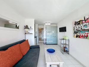 a living room with a couch and a table at Appartement T2 rénové vue mer pour 4 personnes a 50m de la plage de Pramousquier in Rayol-Canadel-sur-Mer
