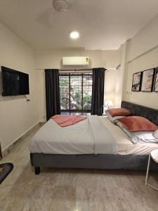una camera da letto con un letto grande e una finestra di Spacious 1BHK Off Carter Road a Mumbai