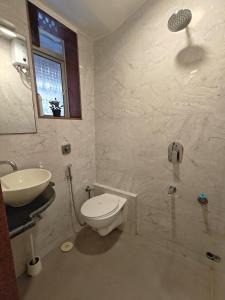 un bagno con un water bianco e un lavandino di Spacious 1BHK Off Carter Road a Mumbai Altre 5 foto