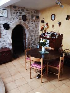 a dining room with a table and a stone wall at Chambres chez l'habitant in Valréas