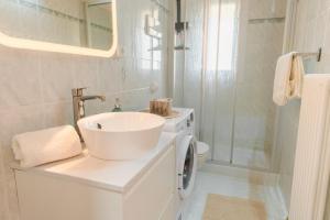 a white bathroom with a sink and a washing machine at Dagi's Dolcevita Apartments in Colà di Lazise +29 photos