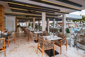 a restaurant with tables and chairs and a pool at Alaia Belize, Autograph Collection in San Pedro