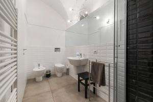 a white bathroom with a sink and a toilet at Casa Ipogea Elegant Apartment in Bergamo +22 photos