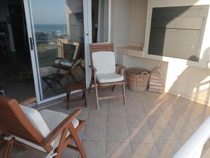 eine Veranda mit Stühlen und einem Flachbildfernseher in der Unterkunft The View No 21 in Jeffreys Bay + 6 Fotos
