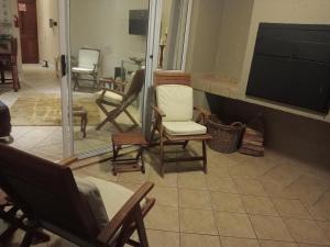 ein Wohnzimmer mit Stühlen und einem Flachbildfernseher in der Unterkunft The View No 21 in Jeffreys Bay