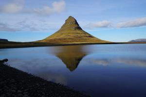 a mountain sitting next to a body of water at The Old Post Office Guesthouse in Grundarfjordur