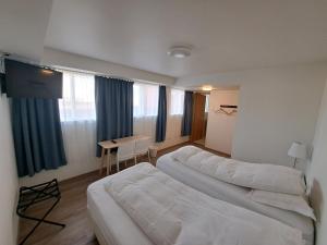 a hotel room with two beds and a desk at The Old Post Office Guesthouse in Grundarfjordur
