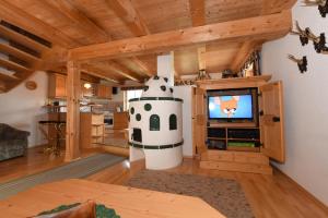 a living room with a tv and a cow statue at Appartementhaus Parzer in Pruggern