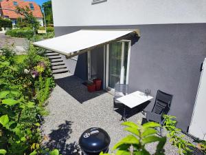 a patio with a white awning next to a building at Le jardin d'Horace o Im Garten von Horaz in Volgelsheim