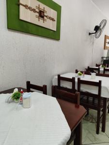 a restaurant with two tables and chairs with white tables at Avenida Plaza Hotel in Pindamonhangaba