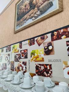 a table with white cups and saucers on a wall at Avenida Plaza Hotel in Pindamonhangaba +16 photos