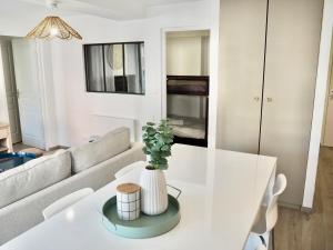 a living room with a white table and a couch at Appart T2 cabine 5 min du centre in Le Touquet-Paris-Plage