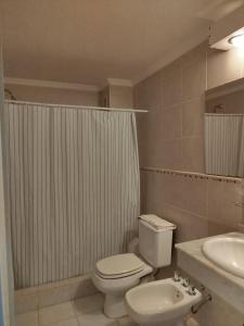 a bathroom with a white toilet and a sink at Brisas del Lago Apartamentos in Colón