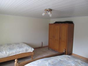WalcourtにあるLes Chèvrefeuillesのベッドルーム1室(ベッド2台、木製キャビネット付)